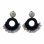 Handmade black thread crochet hoop earrings with oxidized silver floral studs and metallic ghungroo beads on a white background.