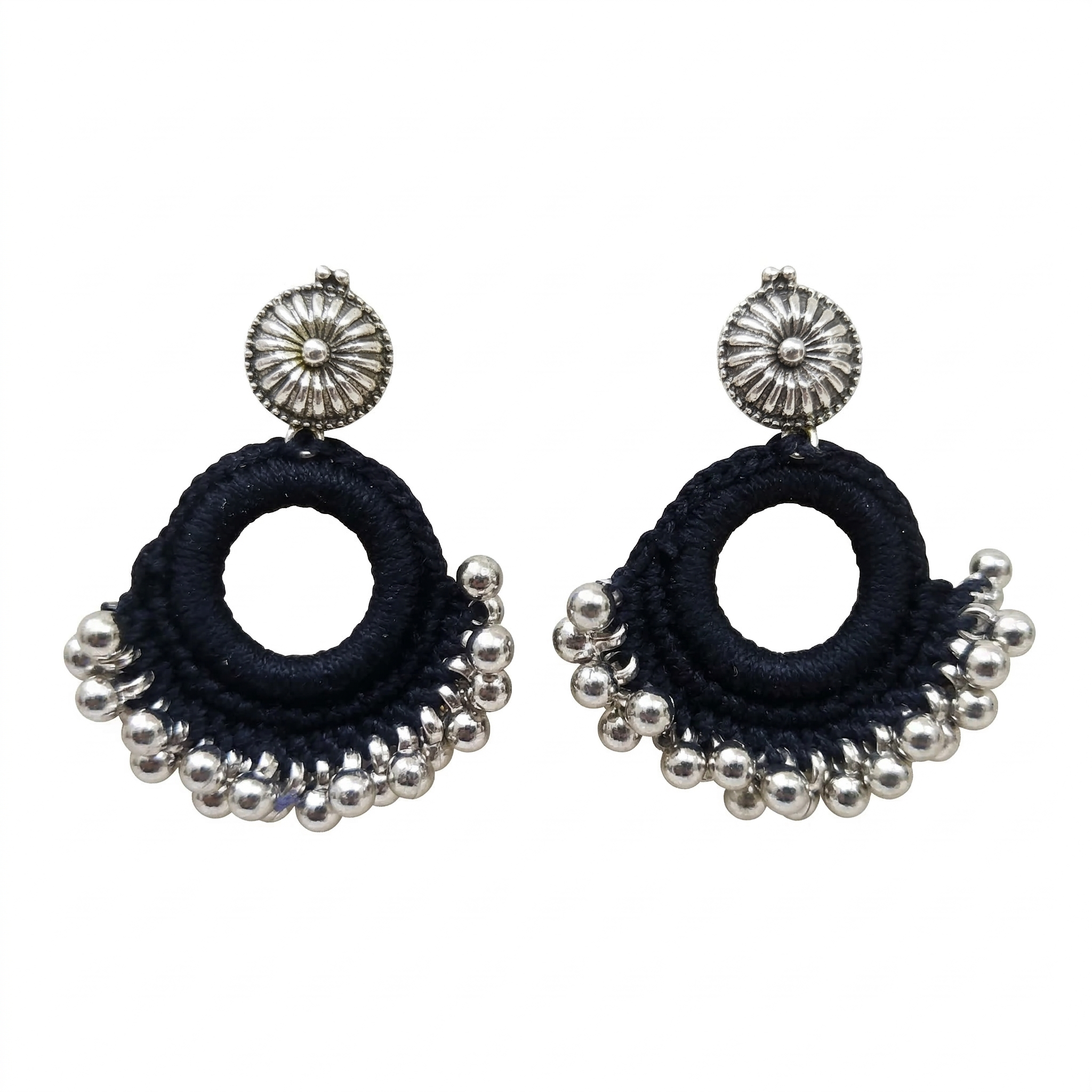 Handmade black thread crochet hoop earrings with oxidized silver floral studs and metallic ghungroo beads on a white background.