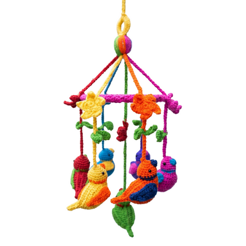 Colorful handmade crochet baby mobile featuring bright yarn birds, flowers, and leaves hanging from a pink ring against a solid white background.