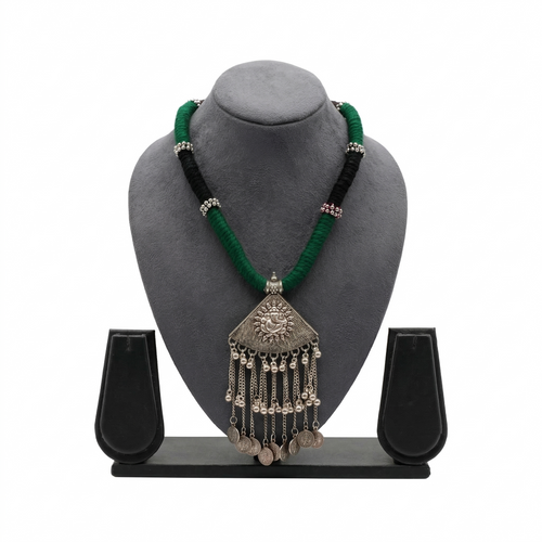 Oxidized silver-tone necklace with a Lord Ganesha pendant, hanging chain tassels, and vintage coin charms on a thick green and black thread cord.