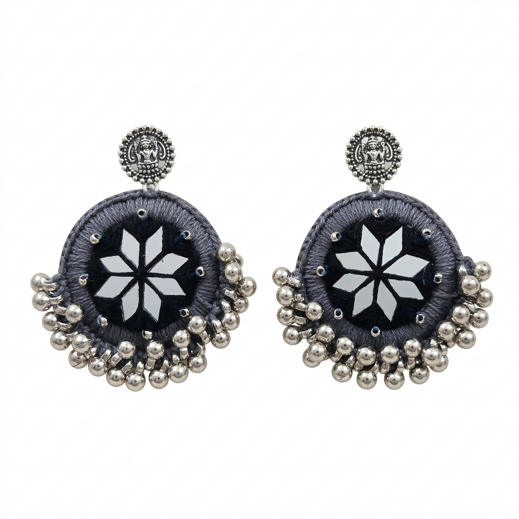 Pair of handcrafted grey silk thread circular earrings featuring star-shaped mirror work and silver metallic ghungroo beads on a white background.