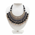 Handcrafted tribal statement necklace on a white display stand featuring a large oxidized silver crescent pendant, textured black beads, and dangling cowrie shells.