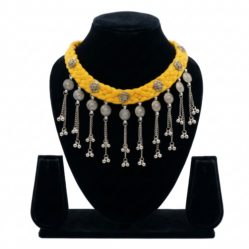 Yellow braided thread choker necklace on a black display stand featuring silver oxidised floral charms and metallic bead fringe.