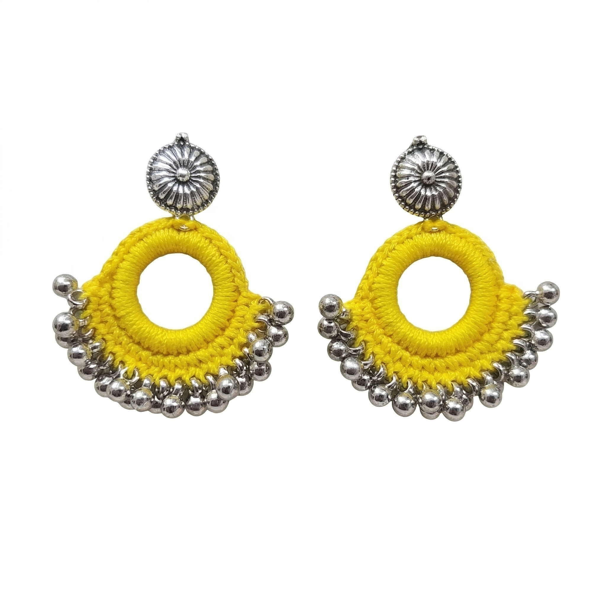 Pair of bright yellow silk thread crochet hoop earrings featuring silver oxidized floral studs and hanging metal ghungroo beads on a white background.