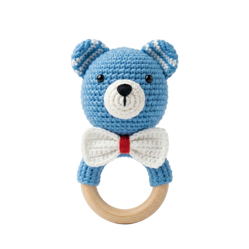A 4K photorealistic blue crochet bear baby rattle with a white bow tie and natural wooden teething ring on a solid white background.