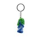 A close-up of a handmade crochet keychain featuring a blue and light blue rose bud with green leaves on a silver metal ring.