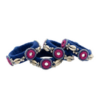 Set of navy blue silk thread bangles featuring white cowrie shells, pink embroidered mirror work, and silver bead accents on a white background.
