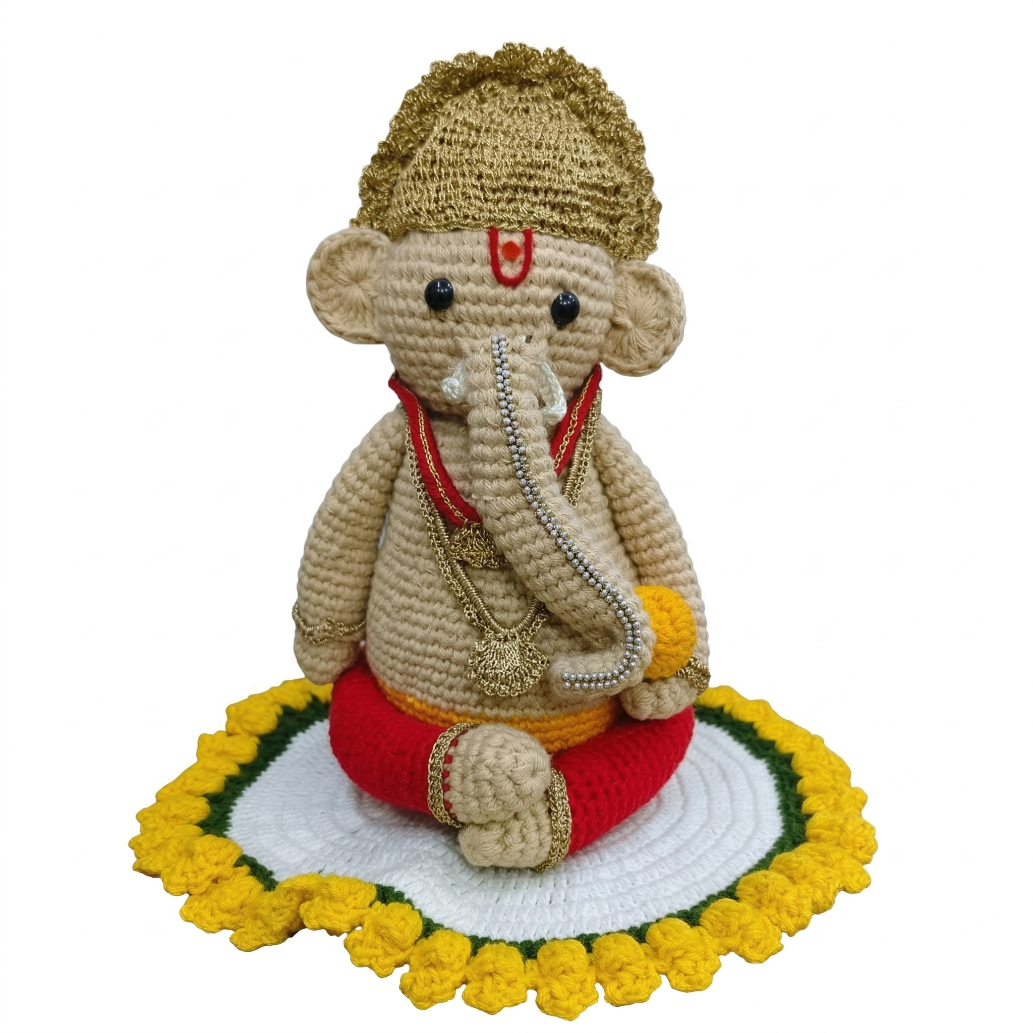 Handcrafted beige crochet Lord Ganesha plush idol wearing a gold crown and red dhoti, seated on a white and yellow knitted lotus base.