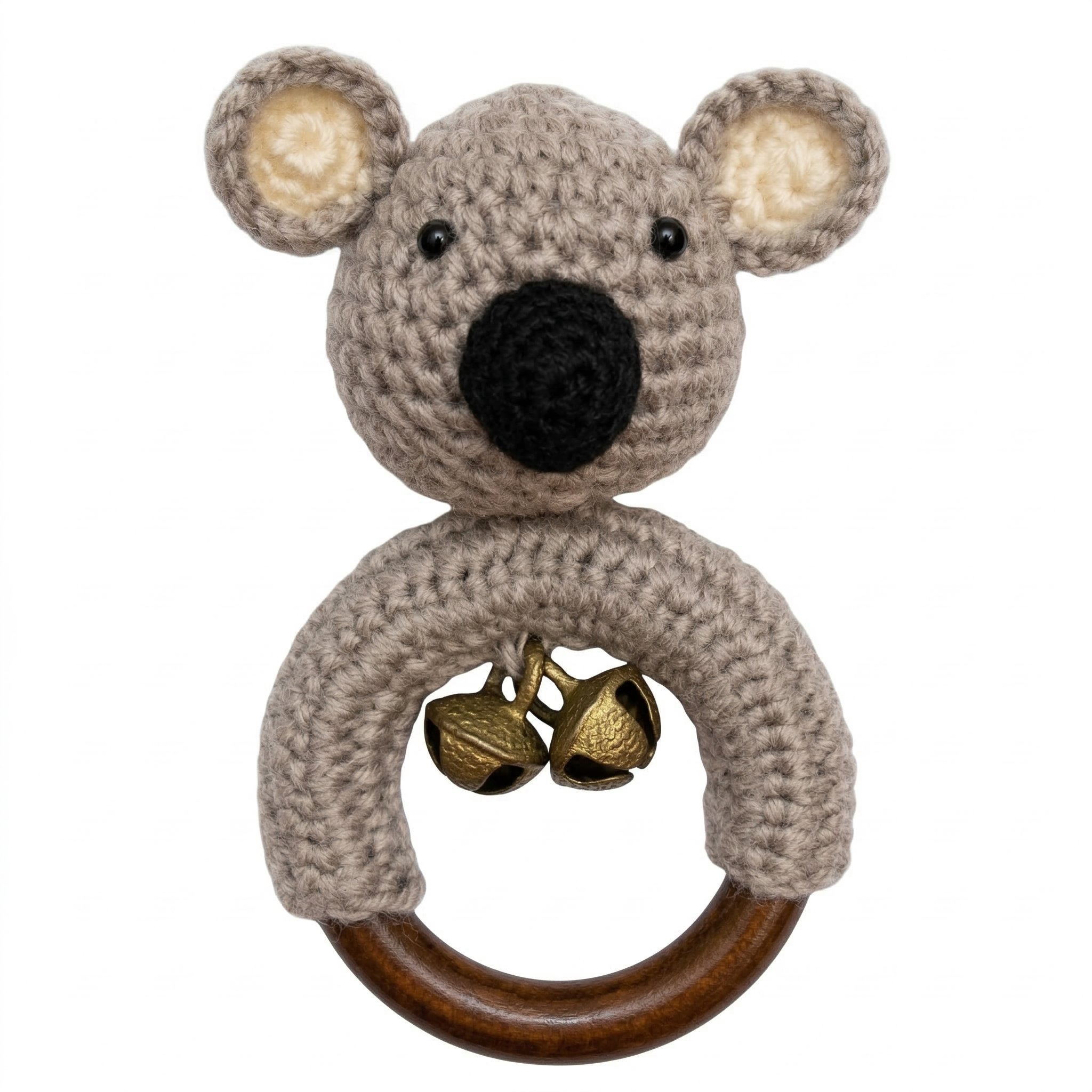 Crochet koala baby rattle toy on a wooden ring with brass bells, isolated on a white background.