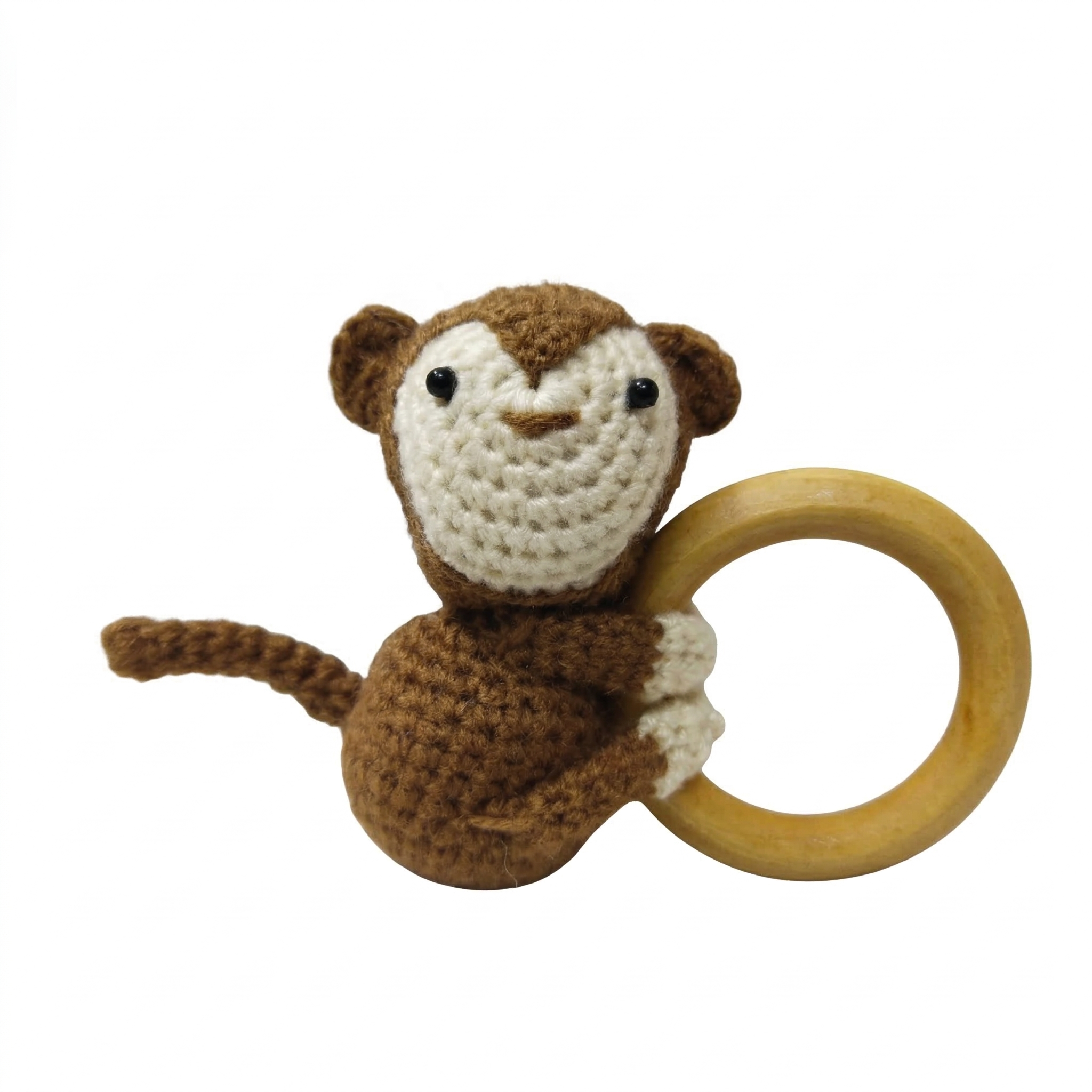 Crochet brown and cream monkey rattle attached to a smooth, natural wooden teething ring on a white background.