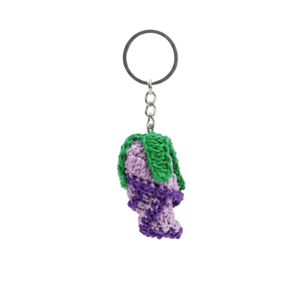 hotorealistic studio shot of a handmade purple and violet crochet flower bud keychain with a green stitched leaf, centered on a solid white background.