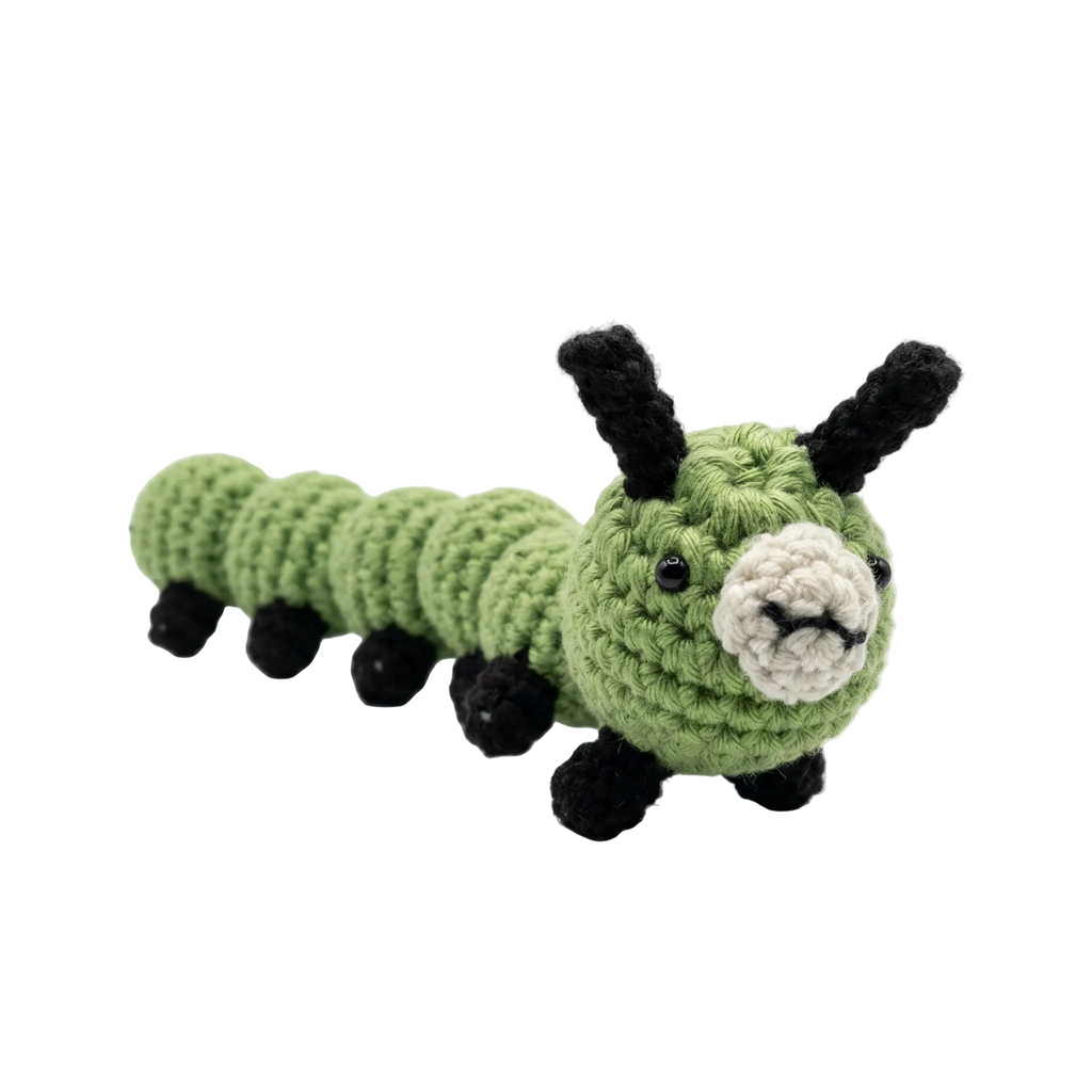 A high-resolution, photorealistic green crocheted caterpillar plush toy with black legs and antennae on a plain white background.
