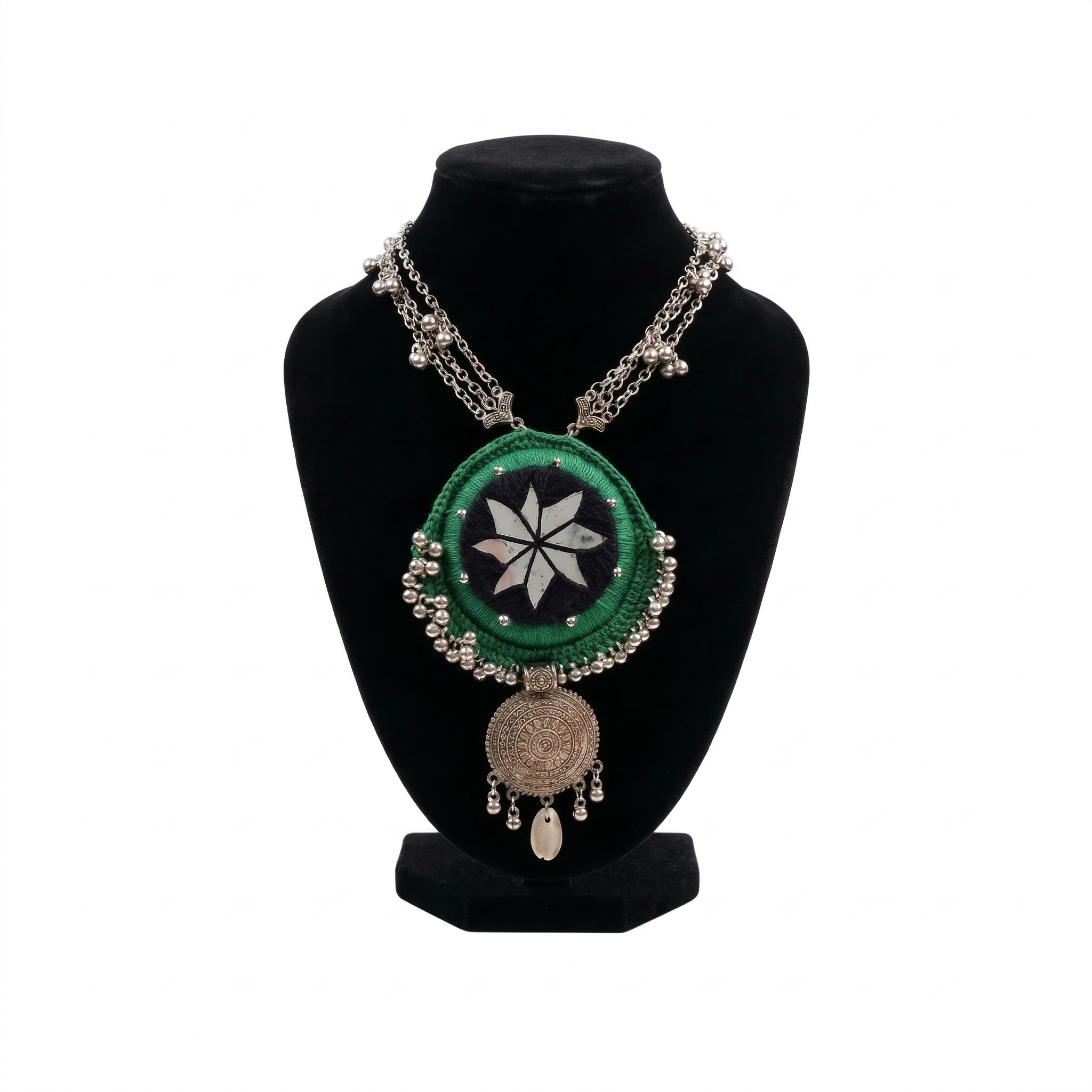 Traditional Indian-style green crochet pendant necklace with mirror work and silver bead trim on a black display stand.