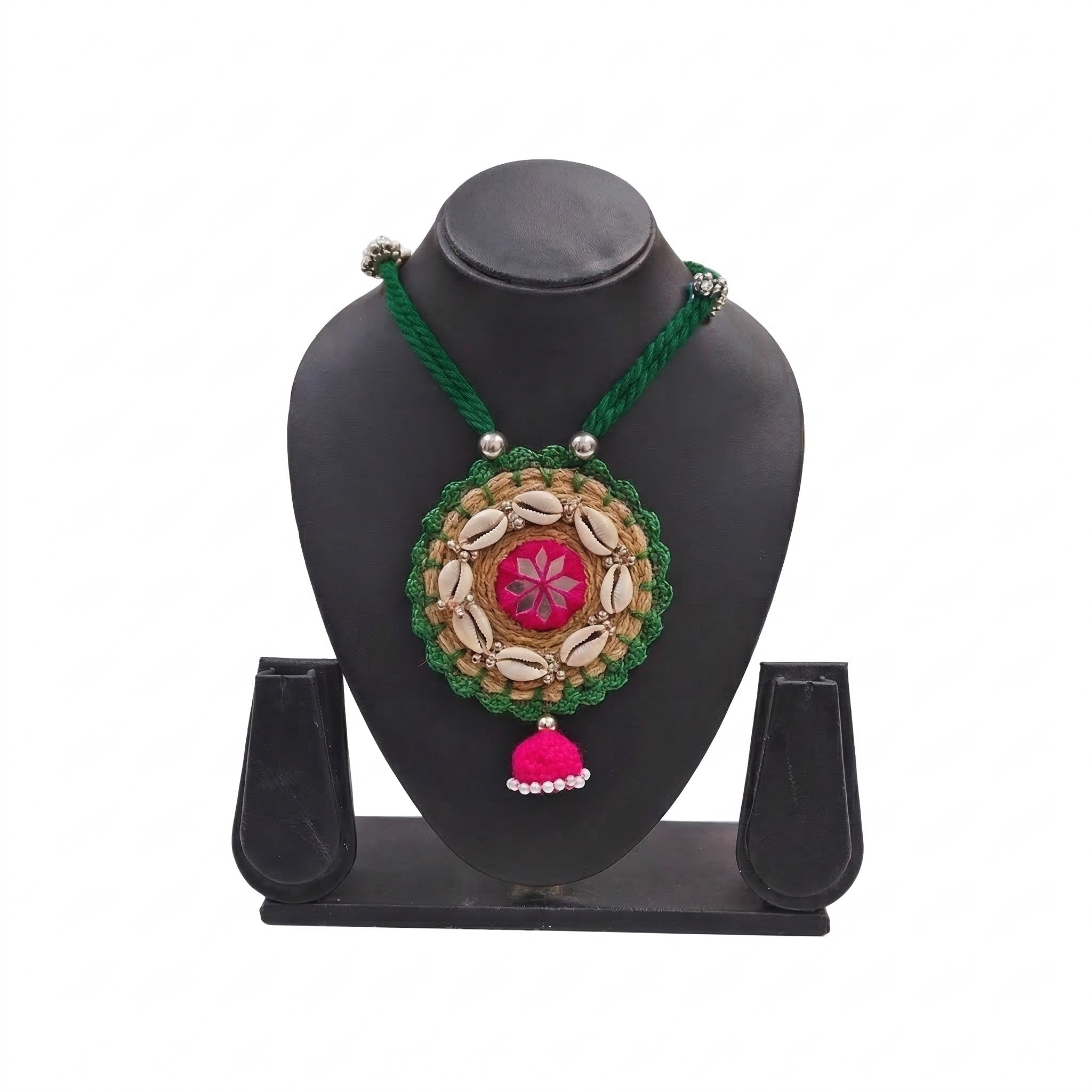 Handmade green and pink tribal necklace with cowrie shells on a black jewelry display stand.
