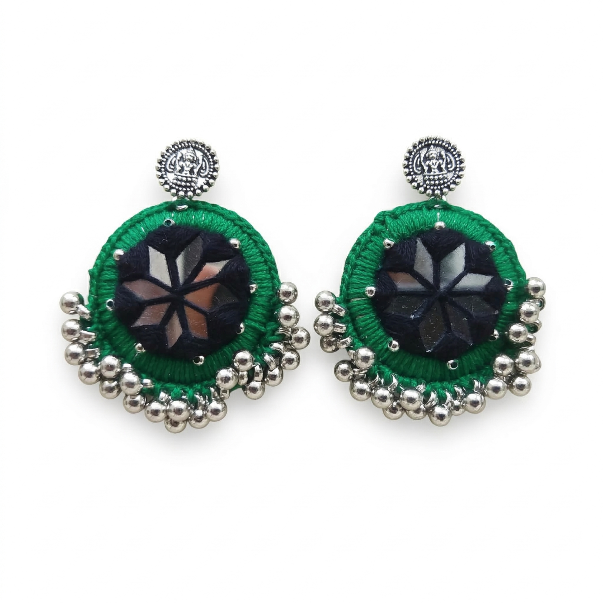 Pair of round green thread-work earrings featuring central star-shaped mirror inlay and silver metallic bead accents on a white background.