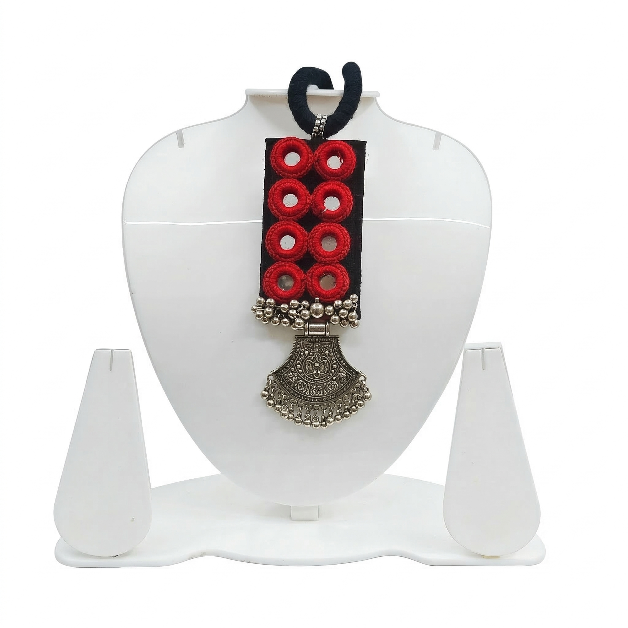 Handmade black fabric necklace featuring eight red-bordered mirrors and a large oxidized silver traditional tribal pendant on a white display stand.