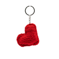 A bright red handmade crochet heart keychain with a silver split ring, hanging against a solid white background.
