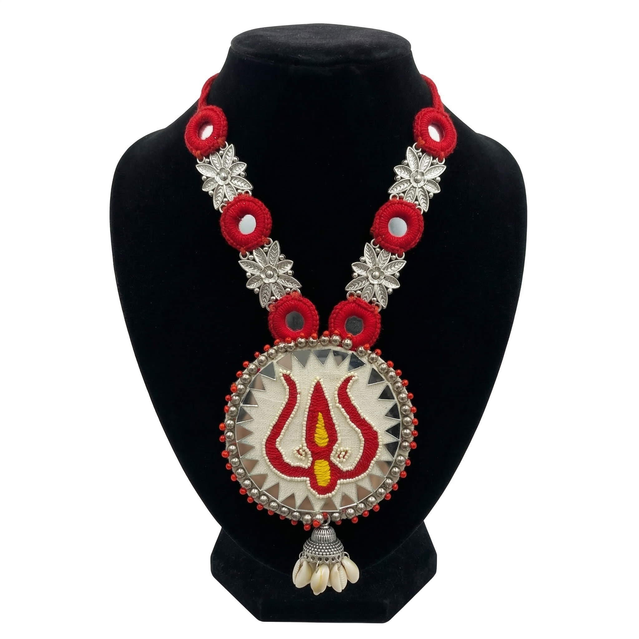 Handmade red and silver ethnic necklace with Trishul embroidery pendant and mirror work on a black jewelry bust, white background.