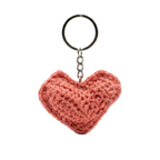 A photorealistic 3D salmon pink crochet heart keychain with a silver metal ring and chain, isolated on a white background.