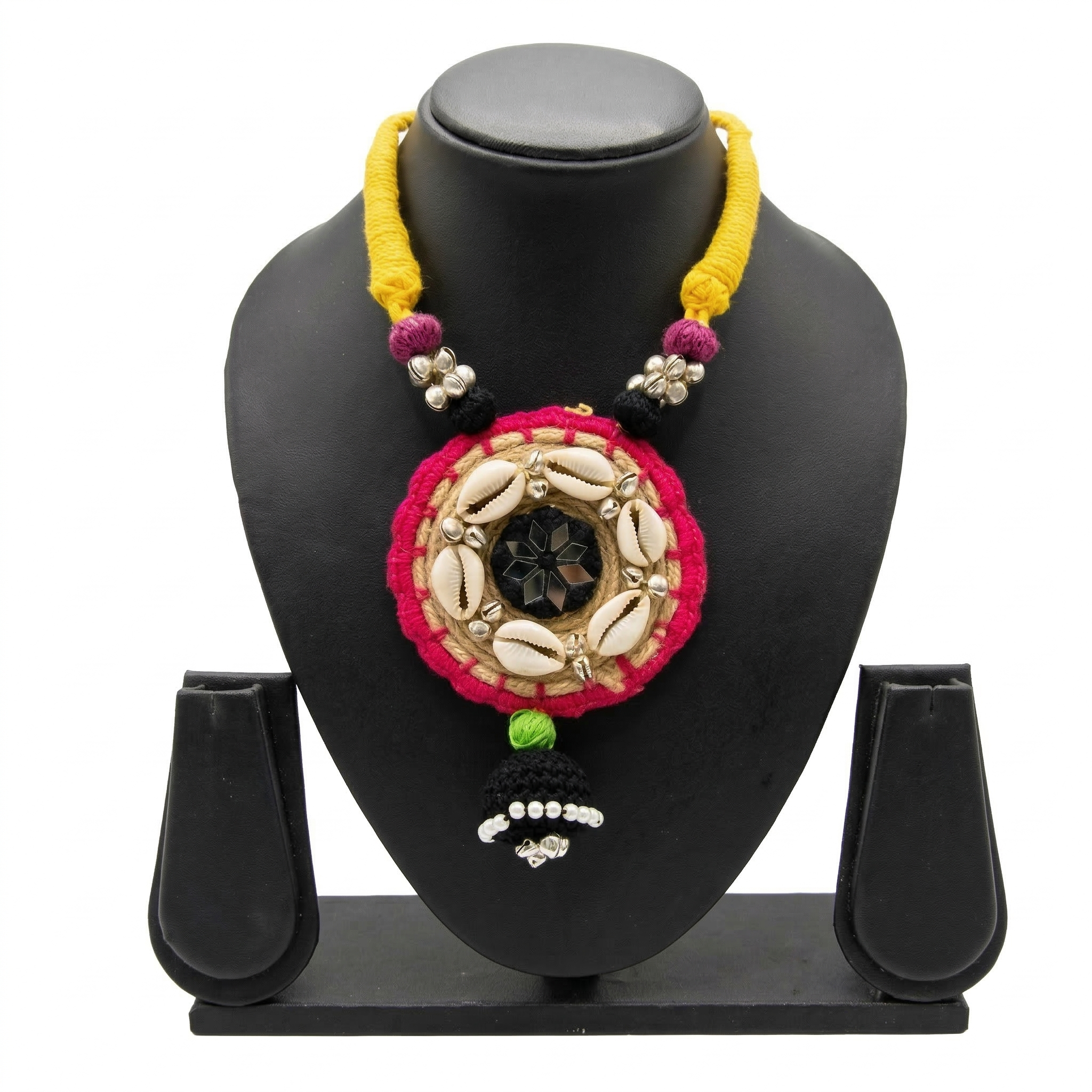 Ethnic handmade necklace with cowrie shells, pink fabric border, and yellow thread cord on a black display stand.