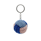 High-resolution product shot of a spherical crochet keychain featuring interlocking patterns of light blue, navy blue, and dusty pink yarn on a silver metal ring, isolated on a white background.