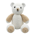 photorealistic studio shot of a white crocheted plush bear with beige arms and feet, sitting against a solid white background.