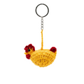 A handcrafted yellow crochet chicken keychain with red accents and a silver ring, isolated on a white background.