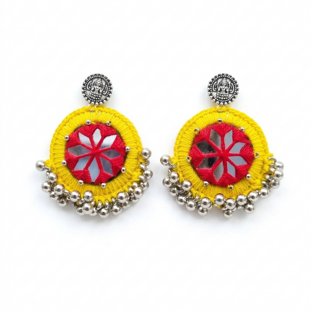 Pair of handmade yellow and red thread-work earrings featuring traditional mirror embroidery and silver bead droplets on a white background.
