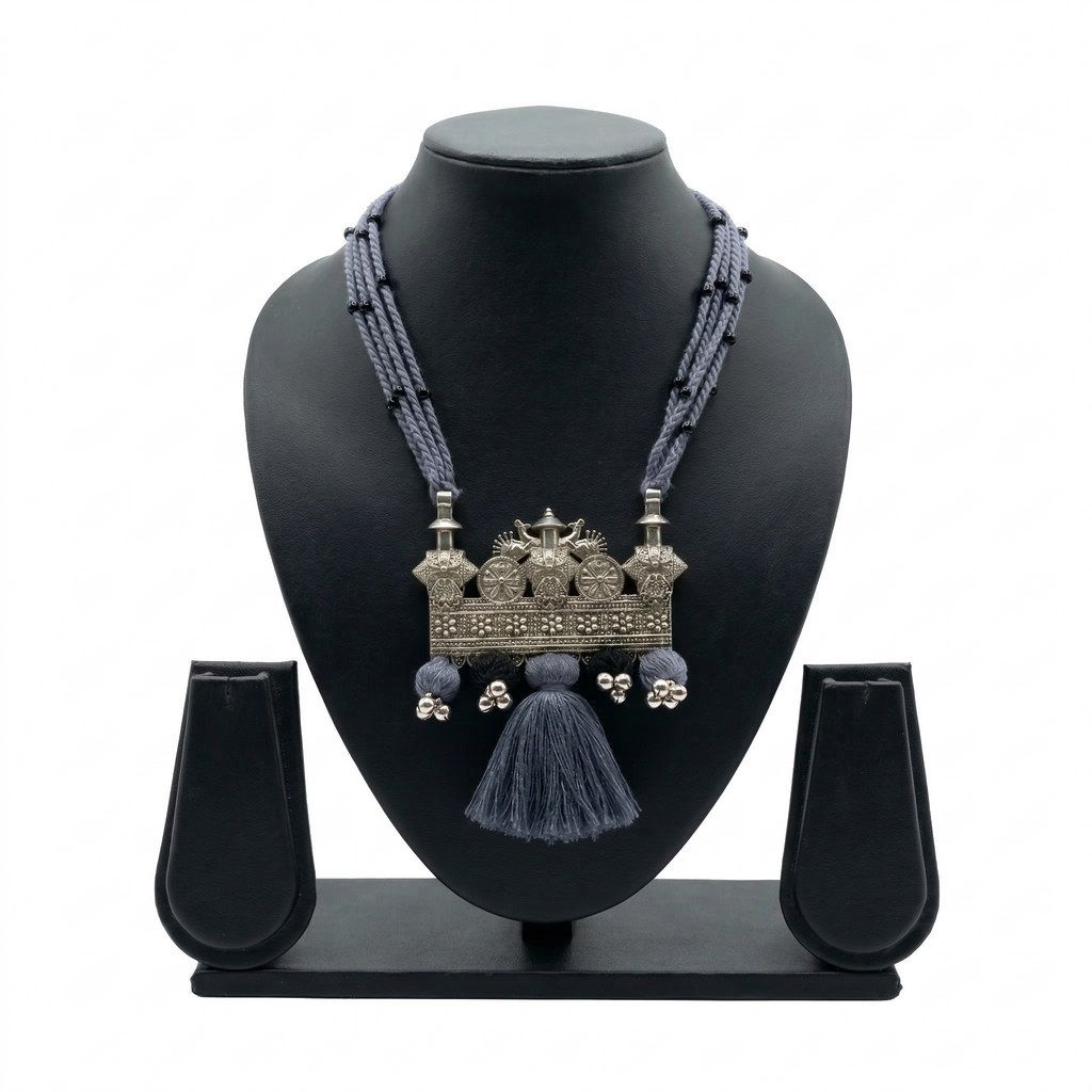 Handcrafted oxidized silver tribal pendant on multi-strand grey thread necklace with tassels.