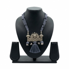 Handcrafted oxidized silver tribal pendant on multi-strand grey thread necklace with tassels.