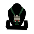 Handcrafted oxidized silver rectangular floral pendant on a layered green silk thread necklace with red accents and tassel.