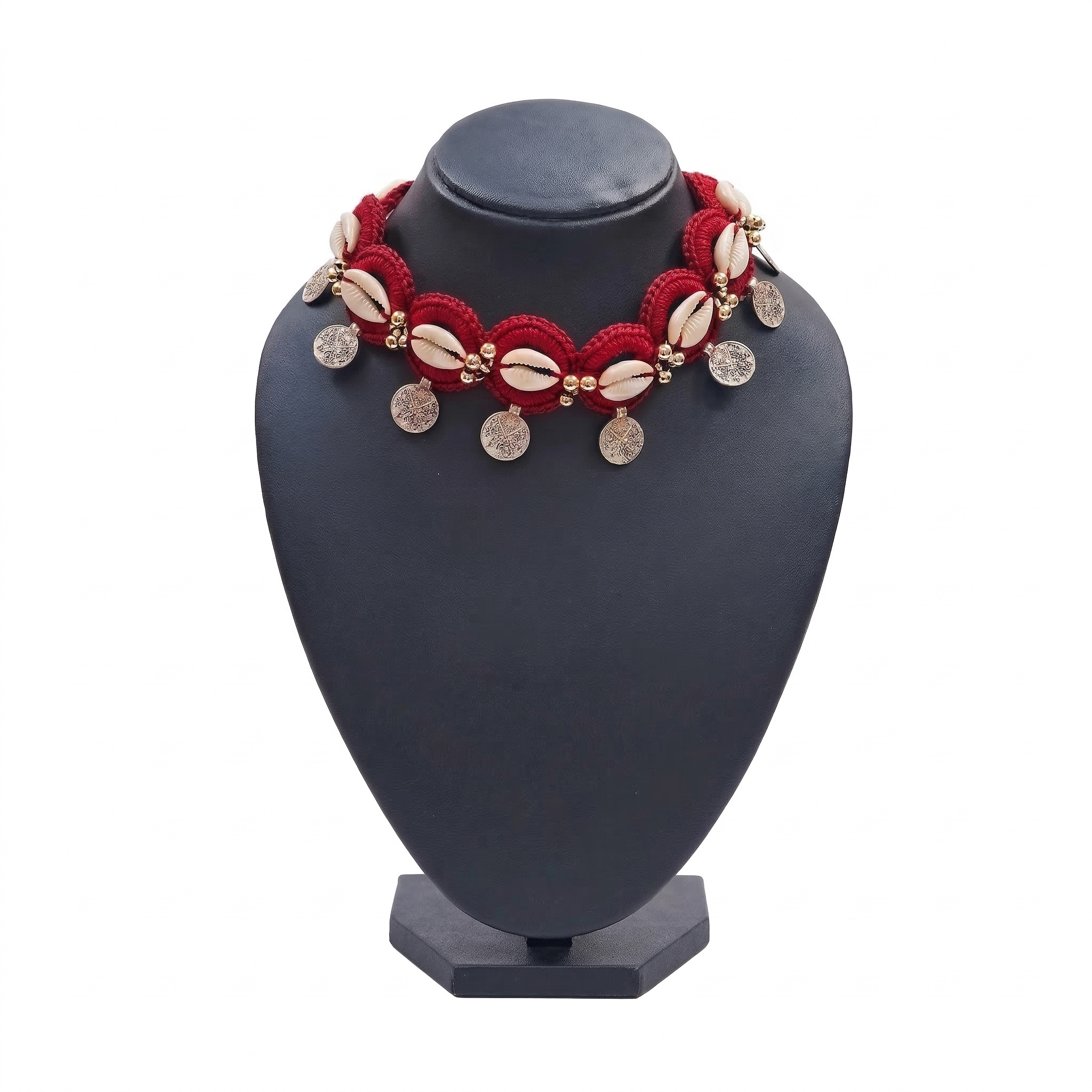 Red handmade crochet choker necklace featuring white cowrie shells, gold beads, and dangling silver-tone coin charms on a black display stand.