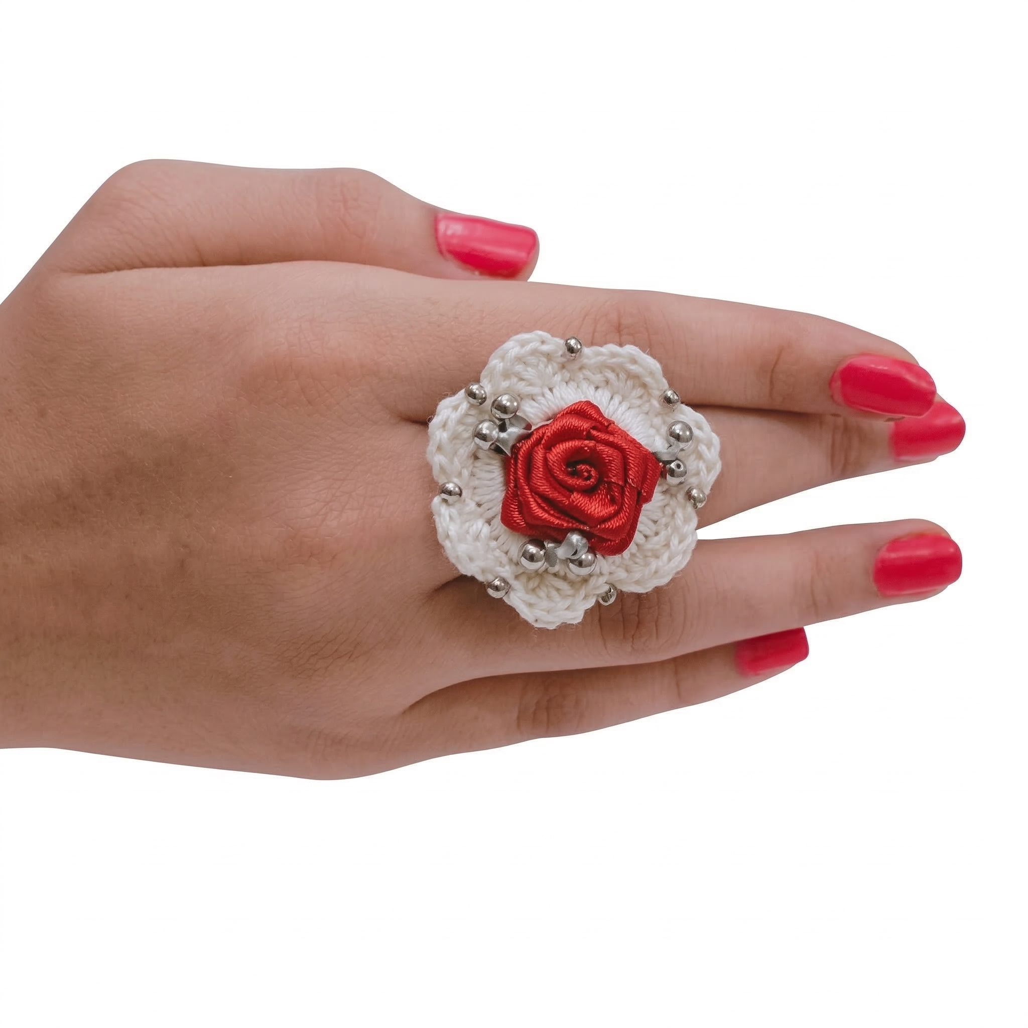 Handmade white crochet flower ring featuring a red satin ribbon rose center and silver bead details on a model's hand.