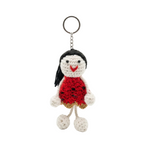 Front view of a white textured tote bag with tan handles, black buckle accents, and a handmade amigurumi girl doll keychain in a red dress against a clean white background.